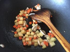 放入土豆和胡萝卜翻炒至土豆表面金黄