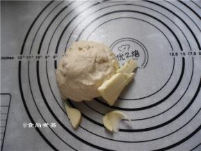 放在案板上充分揉匀，揉至面团有一定的扩展性、加入黄油，继续揉面团，直至黄油均匀地混入面团中