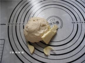 放在案板上充分揉匀，揉至面团有一定的扩展性、加入黄油，继续揉面团，直至黄油均匀地混入面团中