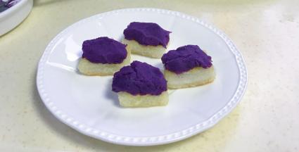 煎好取出放盘中，每片年糕上涂上紫薯馅