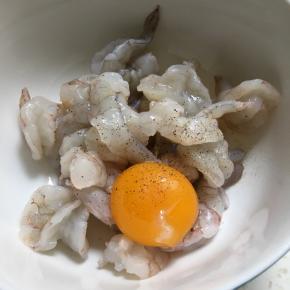 加蛋黄、胡椒粉、料酒和盐，搅拌均匀腌五分钟