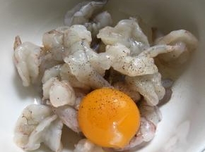 加蛋黄、胡椒粉、料酒和盐，搅拌均匀腌五分钟