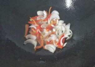 锅中入适量油，放入洋葱丝和红椒丝先翻炒一下；