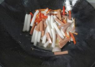 然后倒入火腿和年糕；