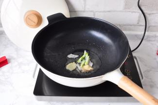 将锅预热，加入凉油，加入葱姜片一起加热炒出香味。