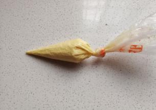 接着把预留的蛋糊装入另一个裱花袋，裱花袋剪一个小口；