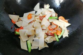 接着放入切好的土豆饼翻炒均匀；