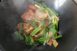 接着下入蒜青翻炒均匀；