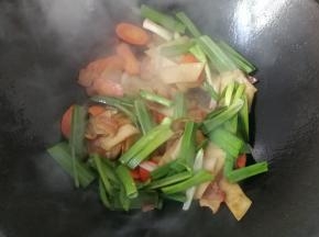 接着下入蒜青翻炒均匀；