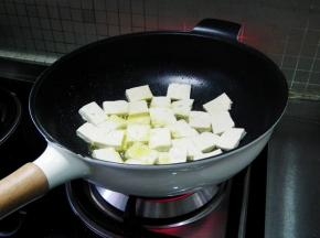 再将豆腐片，一片一片下入锅中。