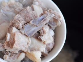 将捞出的羊排放入锅中。