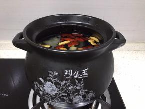 将煲放灶台上小火，加入一大块冰糖入煲中