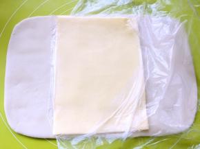 取出冷冻的黄油片，用简单裁开保鲜袋，将黄油片铺在面片中间