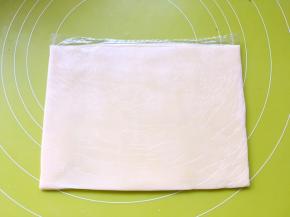 之后对折保鲜袋，用擀面杖将黄油擀成均匀的薄片，入冰箱冷冻