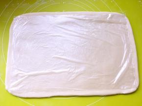 冰箱取出冷冻的面片，室温回下温度，让面片变软一点，用保鲜膜检查一下大小，小的话，可以再稍稍擀大一点点