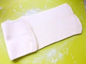 撒点干粉，用擀面杖擀成长条，力度要轻，从中间开始向前擀，干粉可以多撒一点，这样面片不会粘在揉面垫上，更好擀