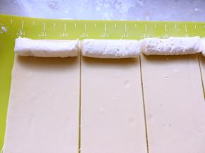 冰箱取出冷冻的奶酪条，切成面片同等宽度，摆放在面片的一侧