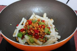 把炒的青辣椒、红辣椒、腊八豆，豆瓣酱、酱油，加入翻炒；