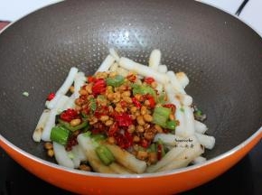 把炒的青辣椒、红辣椒、腊八豆，豆瓣酱、酱油，加入翻炒；