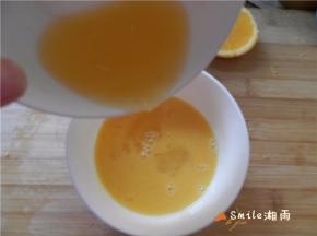 将橙汁倒入蛋液中搅匀。