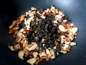 香菇变软时放入木耳翻炒均匀。