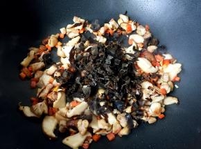 香菇变软时放入木耳翻炒均匀。