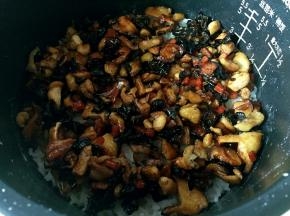 电饭煲的饭显示还有15分钟好的时候放入炒好的香菇鸡腿肉。盖上盖子焖15分钟即可。