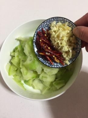 萝卜片中加入蒜蓉和红辣椒。