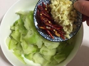 萝卜片中加入蒜蓉和红辣椒。