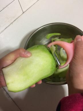 用削皮器把萝卜削成薄片。