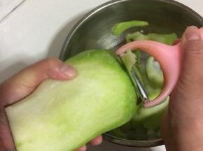 用削皮器把萝卜削成薄片。
