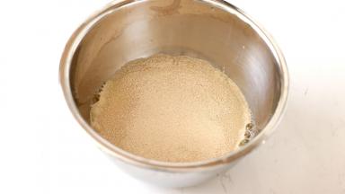 水+全蛋打匀后加入需要酵母粉。然后倒入混合好的【步骤1】中。揉至面团成团看不见干粉时再加入黄油和猪油（这一步忘记拍照了。。）