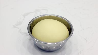 取出我们发酵好的面团。和吐司的检测方法相同，手指沾少量面粉，中间戳一下，有孔洞不回缩即可。