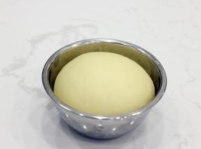 取出我们发酵好的面团。和吐司的检测方法相同，手指沾少量面粉，中间戳一下，有孔洞不回缩即可。