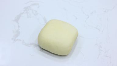 翻面我们就可以得到一个正方形面团。覆盖保鲜膜，室温下松弛醒发20分钟