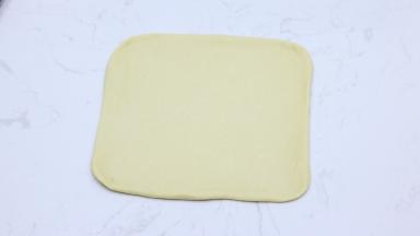 轻拍排气后，用擀面杖擀成大约30cm*30cm的正方形面片。
