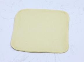 轻拍排气后，用擀面杖擀成大约30cm*30cm的正方形面片。