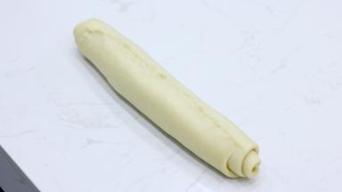 将放凉的甘纳许均匀涂抹在面片上。注意底部预留2cm左右不要涂抹。然后从上到下卷起，收口位置一样要捏紧（这一步漏拍了一个涂抹巧克力甘纳许的图）