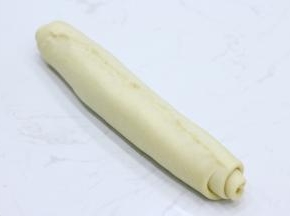 将放凉的甘纳许均匀涂抹在面片上。注意底部预留2cm左右不要涂抹。然后从上到下卷起，收口位置一样要捏紧（这一步漏拍了一个涂抹巧克力甘纳许的图）