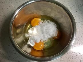 无水无油的打蛋盆里磕入3个鸡蛋，一次性倒入细砂糖。