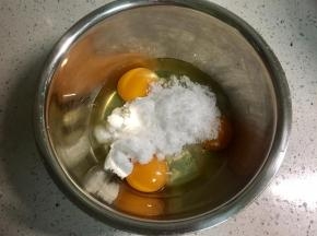 无水无油的打蛋盆里磕入3个鸡蛋，一次性倒入细砂糖。