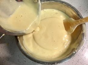 然后再把拌匀的黄油牛奶面糊加到剩余的鸡蛋面糊里。