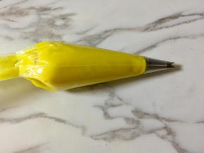 加厚的裱花袋底部剪一个小于裱花嘴口径的口，把352号裱花嘴放进去，再把豆沙装入裱花袋。