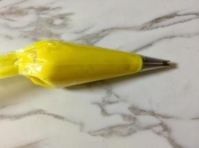 加厚的裱花袋底部剪一个小于裱花嘴口径的口，把352号裱花嘴放进去，再把豆沙装入裱花袋。