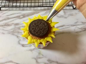 再在两边花瓣之间的位置，靠近奥利奥饼干的边缘，挤上一圈花瓣。