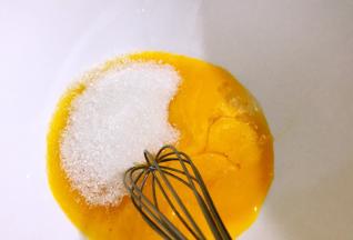 蛋黄里加入一半的白糖，拌匀