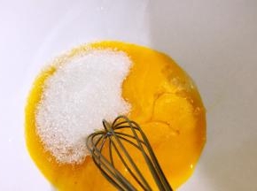 蛋黄里加入一半的白糖，拌匀