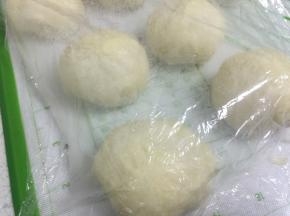 然后将发酵好的面团取出，分割成10个平均56g一个大小。盖上保鲜膜醒面15分钟