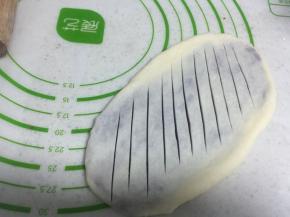 然后拿刀在面包表面上划十几刀， 不切太深