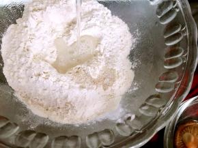 把清水加入高筋面粉里，边加水边搅拌